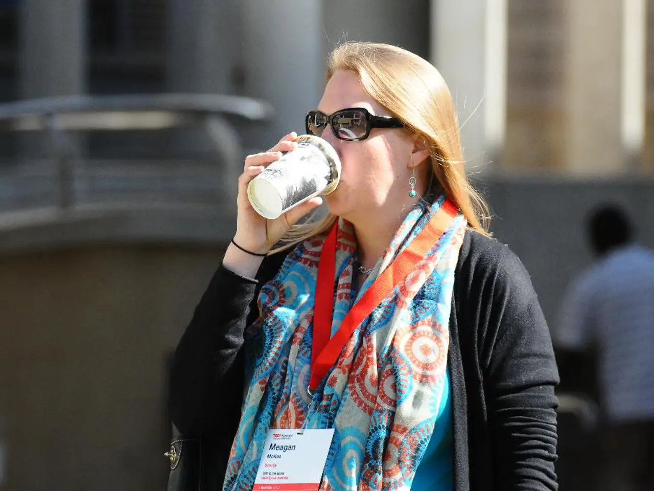 In the image here is a woman she is drinking some drink, she is wearing goggles and there is an...