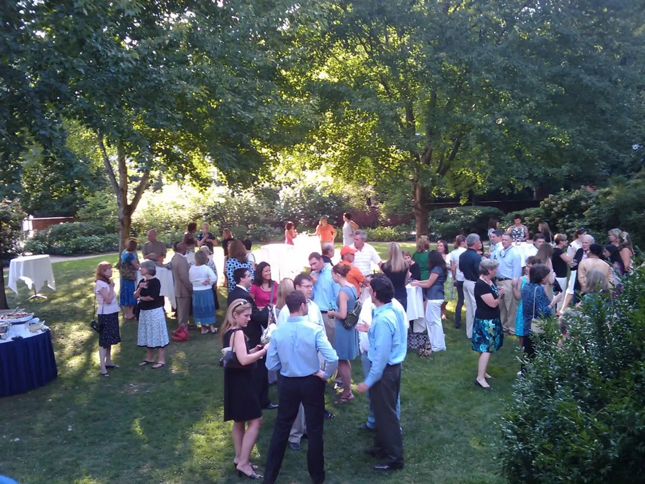 On the right there are plants and trees. In the center of the picture there are people standing. On...