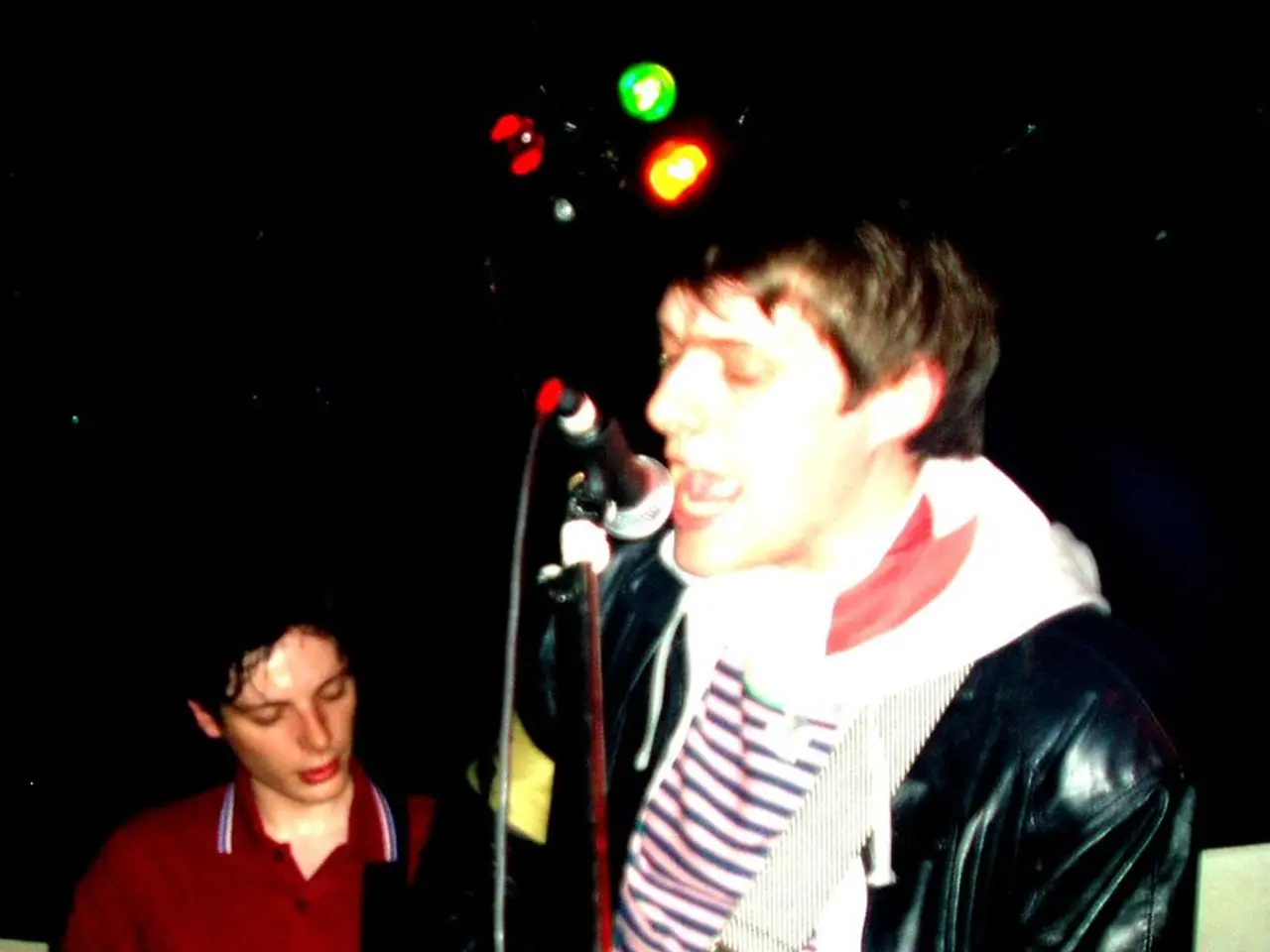 This picture is clicked in a musical concert. Man in black jacket is holding guitar in his hands...