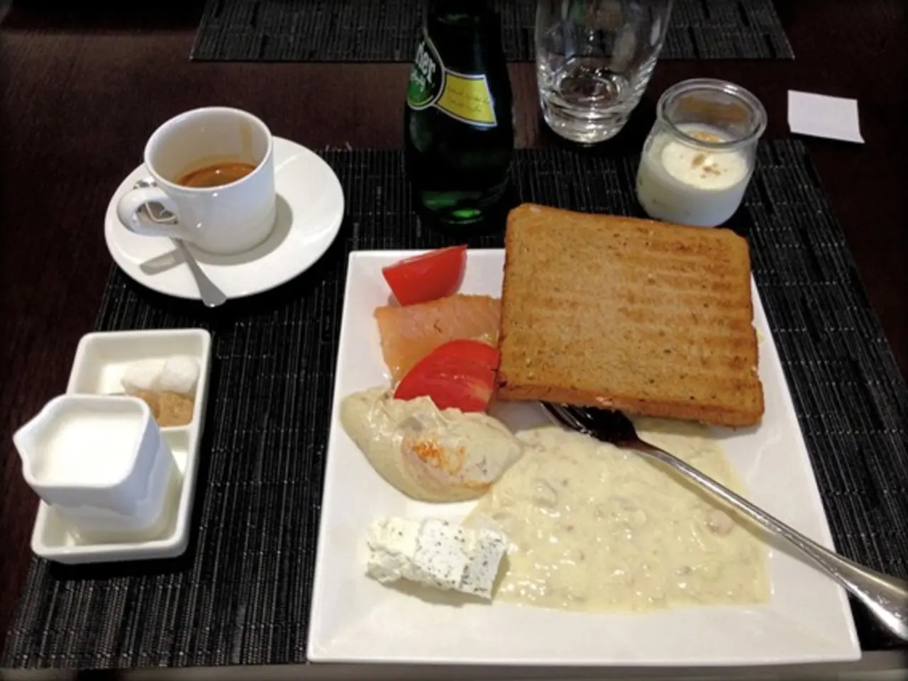 In this picture we can see a brown bread and cream on the white plate, placed on the dining table....