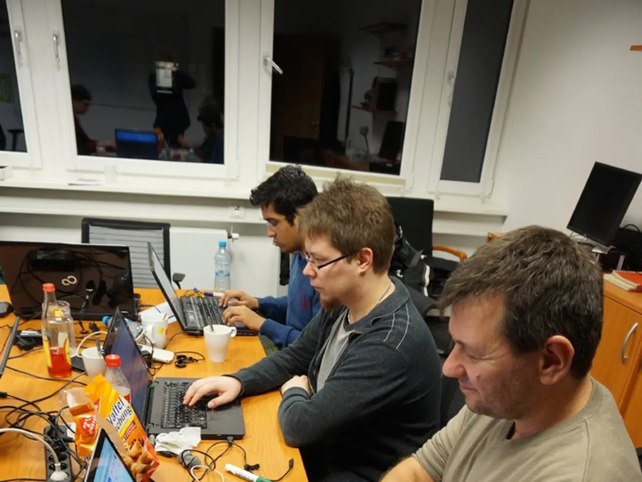 This picture describes about three people they are seated on the chair and working on their...