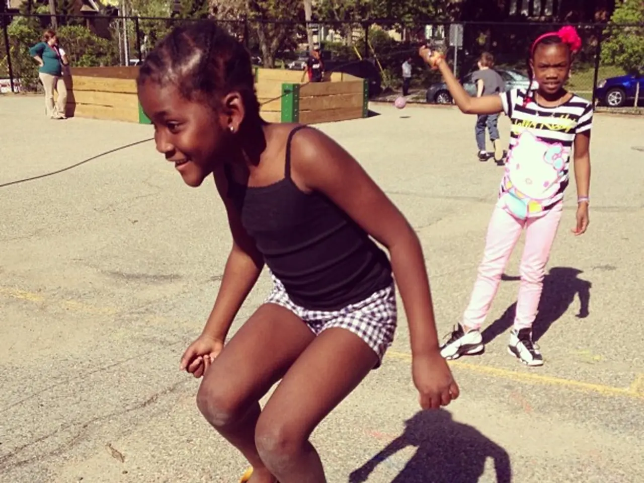 As we can see in the image there are few people here and there, fence, trees and in the background...