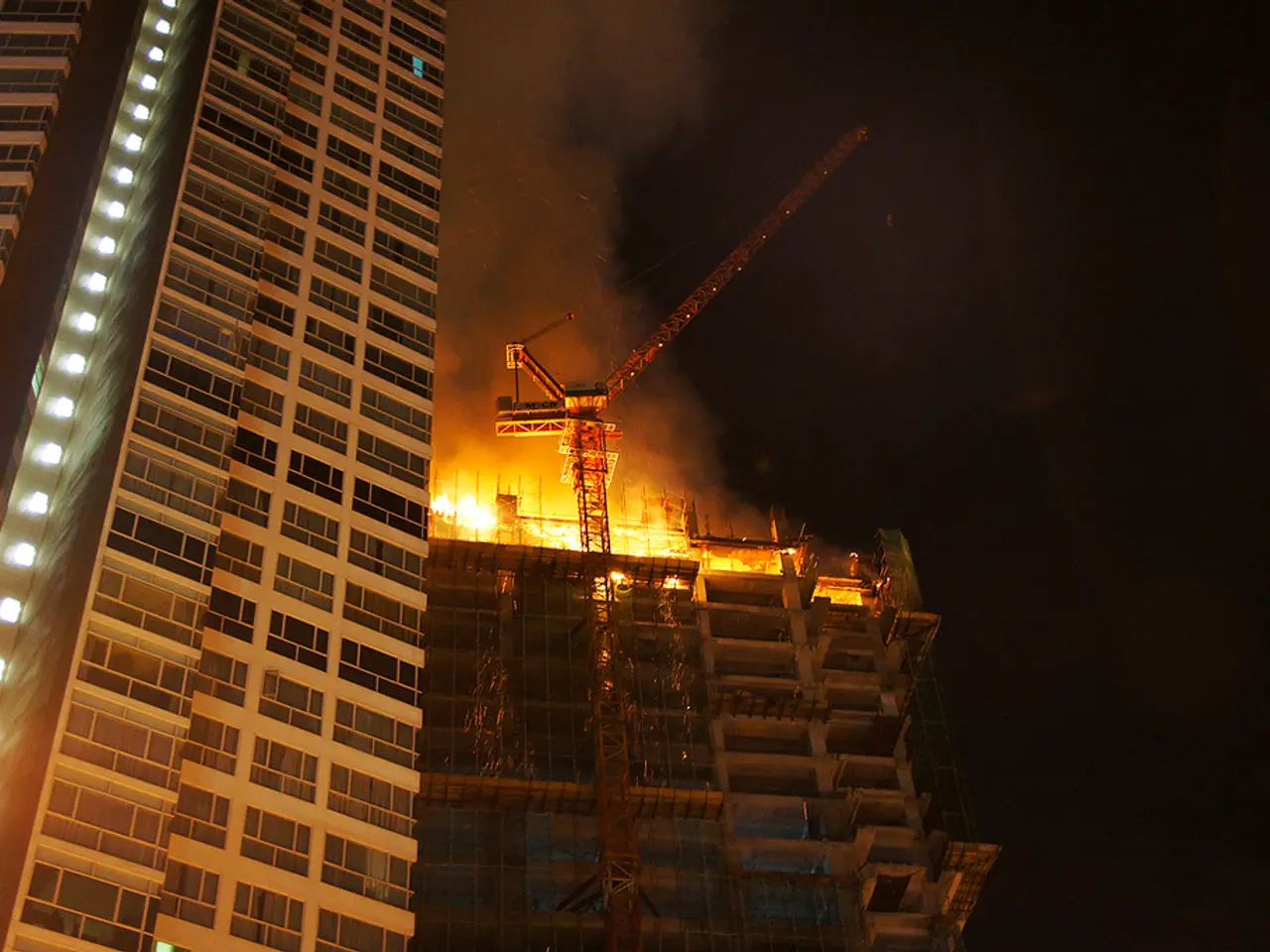 In this image there are two buildings, in which there is a fire in a building,and in the background...