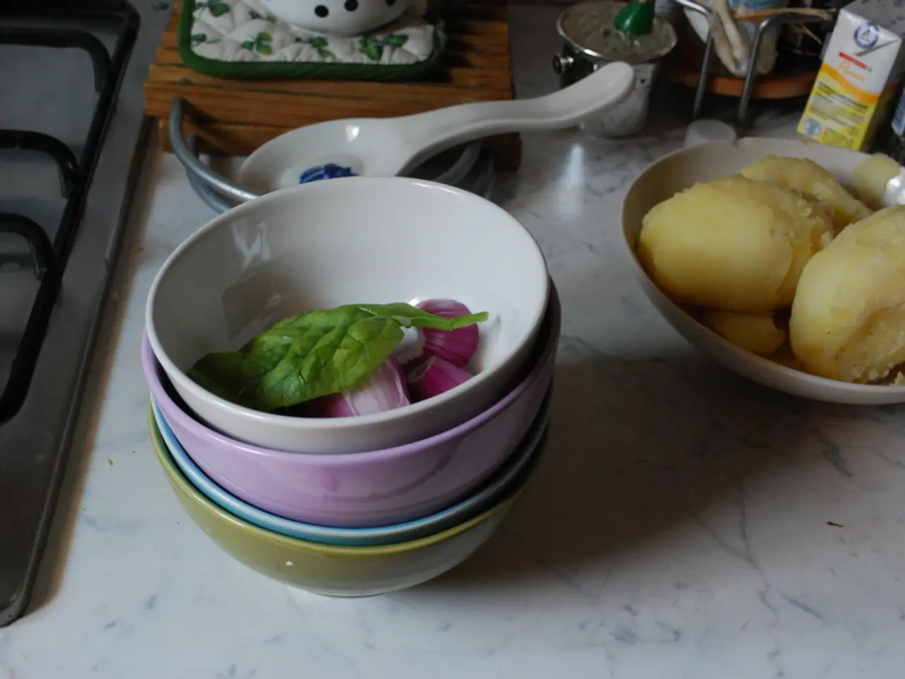 On the table there are some bowls. Inside the bowl there is a leaf and an onion. To the right side...