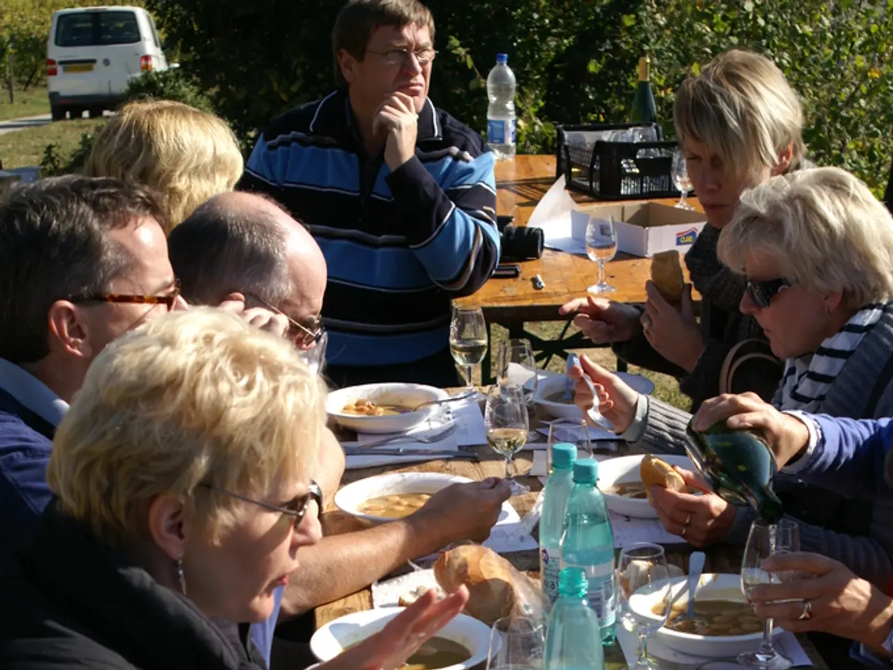 In this picture a group of people sitting and they have a table in front of them and they are...