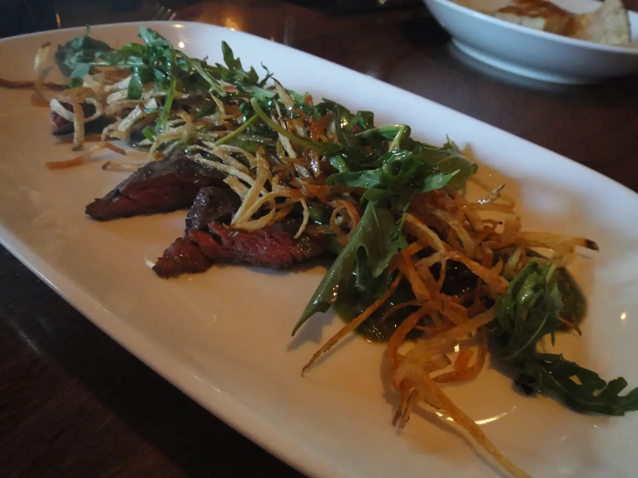 In this image we can see food placed in a serving plate and a serving bowl and are placed on the...