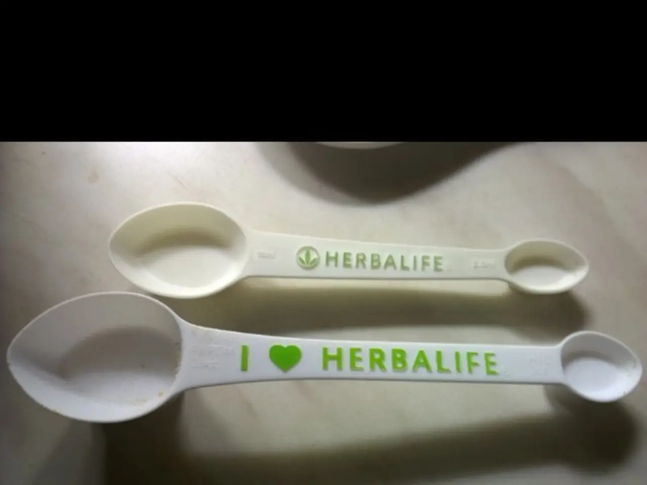 In the center we can see table. On table,there is a spoon written as "Herbalife".