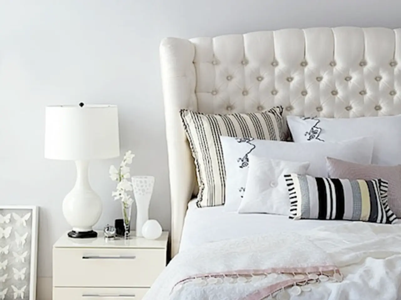 On the left we can see desk, lamp, flower vase, frame, wall and other objects. On the right we can...