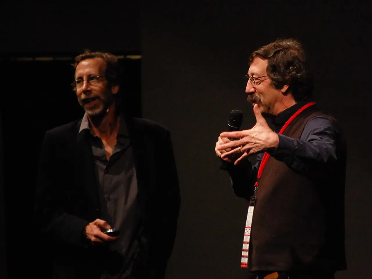 Hindi picture there are two men in photograph. In the front there is a man wearing black coat is...