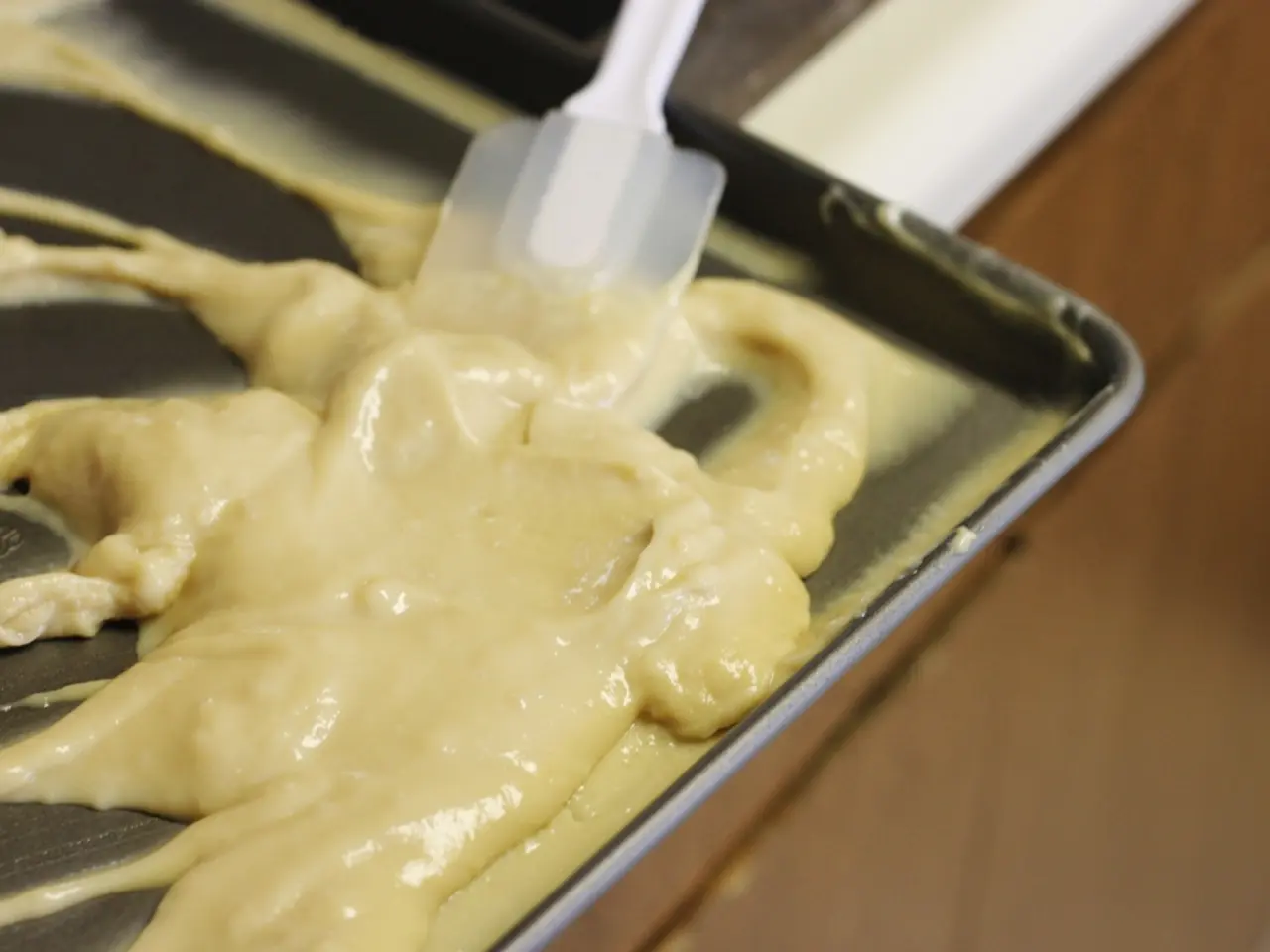 In this picture we can see a tray with a spoon and a cream on it and this tray is placed on a...