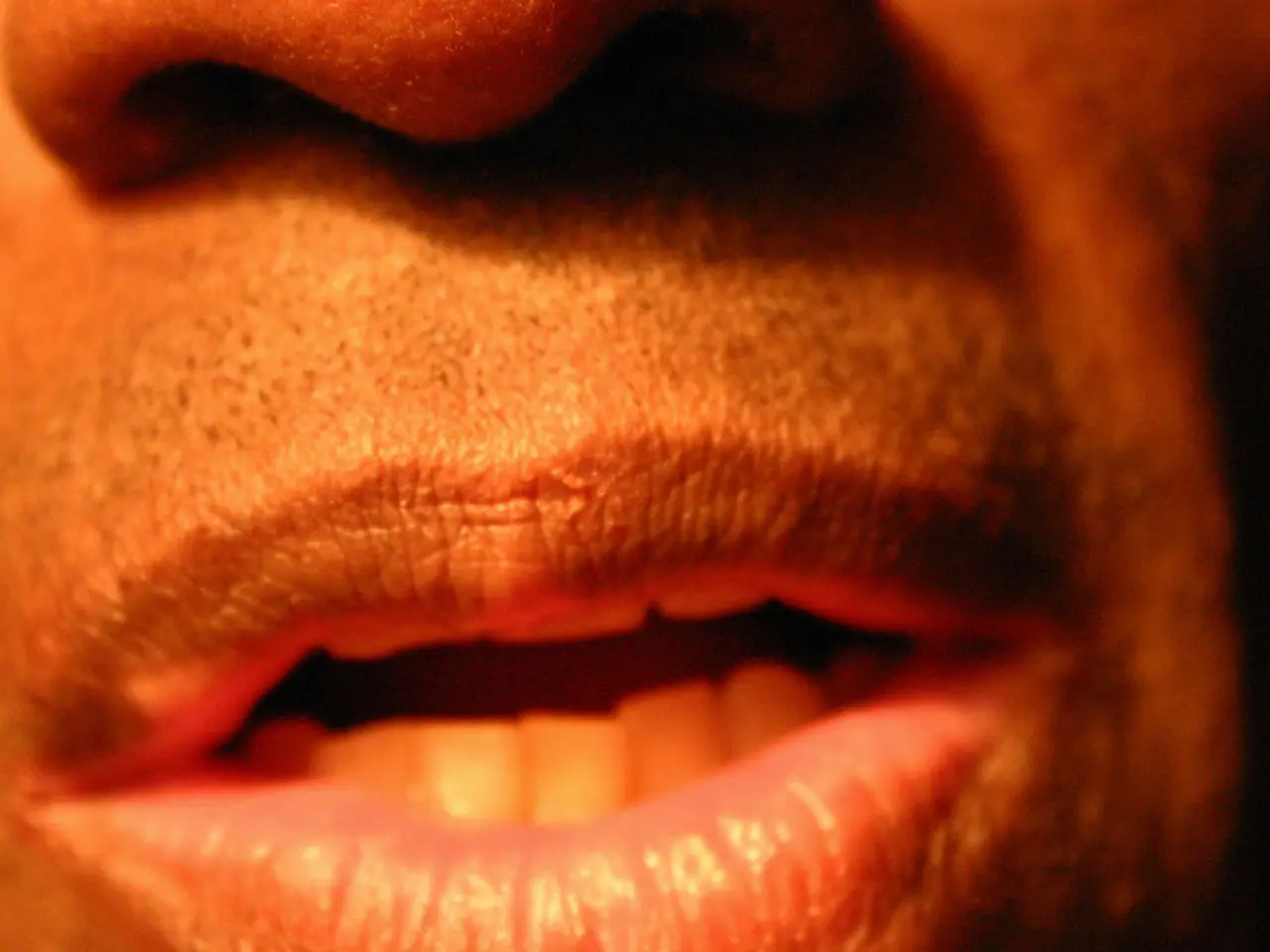 In this picture I can observe mouth of a human. On the top of the picture there is a nose. I can...