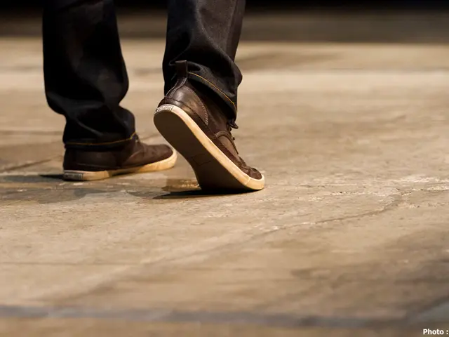 In this image we can see person's legs with footwear on the floor. At the bottom on the right side...