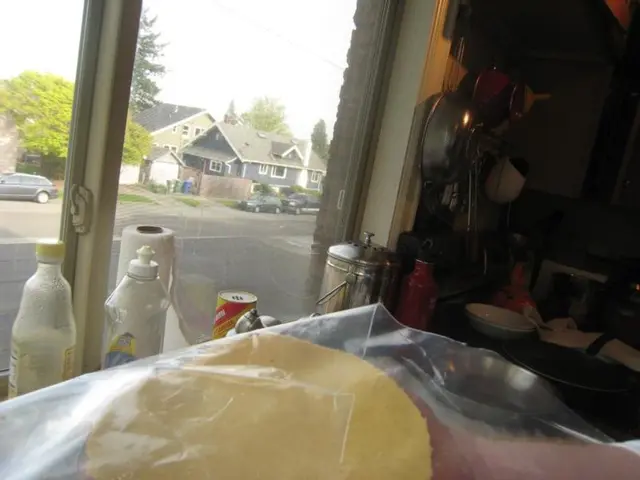 It is a kitchen inside a house, there are kitchen utensils on the table, a pan and in front of the...