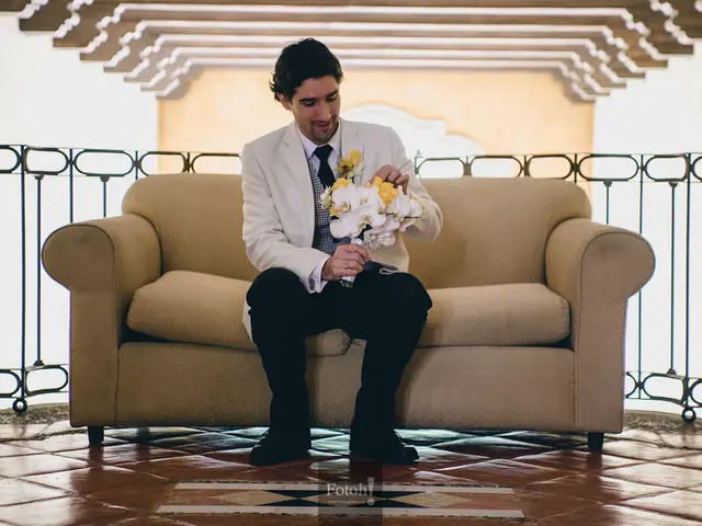 In this image there is a man wearing a suit,Tie,trouser and shoes. he is holding a bouquet with a...