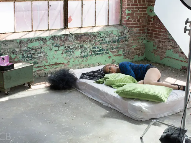 In this image a woman is lying on the bed which is having a blanket and a pillow on it. Left side...