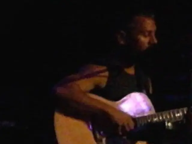 In this picture we can see a person is holding a guitar in his hands, and playing it.