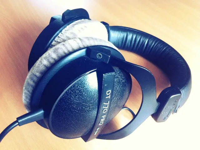 In the image there is a headphones on a wooden table.