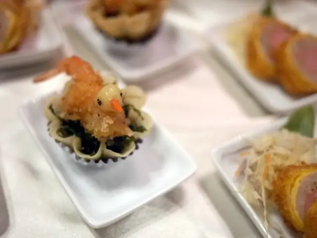 In this picture there are some snack in the white plate which is placed on the table top.