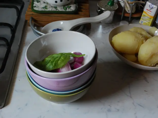 On the table there are some bowls. Inside the bowl there is a leaf and an onion. To the right side...