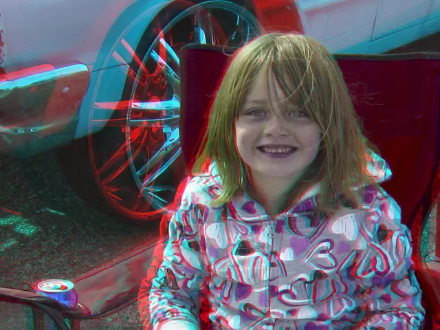 In this image a girl is sitting on the chair. She is having a book and a pen on her lap. Behind...