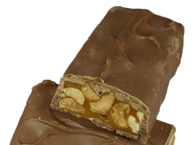 In this image there are two pieces of chocolate and nuts in it.