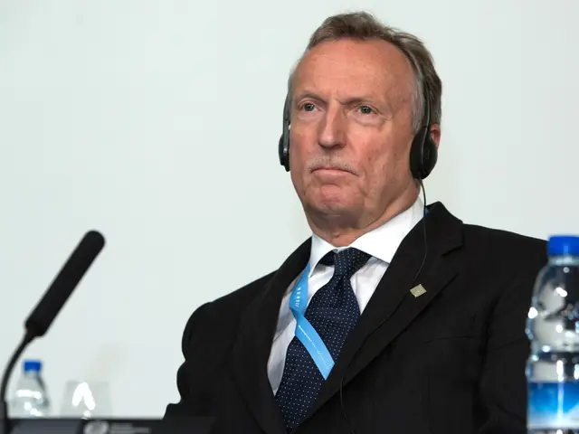 A person is sitting on the chair,he is wearing headset. In front of him there is a microphone and...