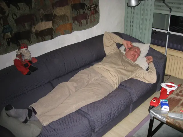 As we can see in the image there is a man sleeping on sofa, a lamp and on the right side there is a...