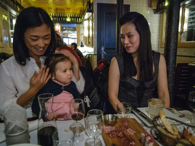 In this image, we can see two women smiling. At the bottom of the image, we can see a kid and...