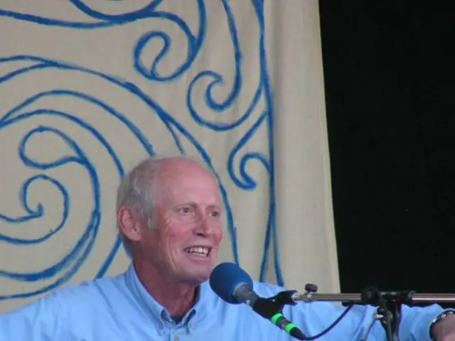 This person is playing guitar and singing in-front of mic. This is mic holder.