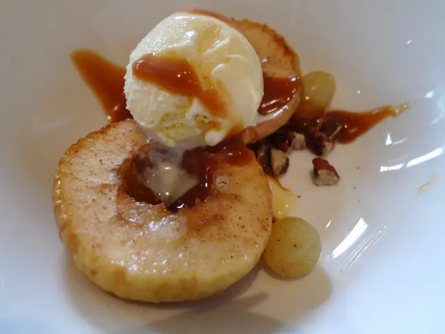 There is an ice-cream arranged on the two pieces of a fruit, near other two fruits, in a white...