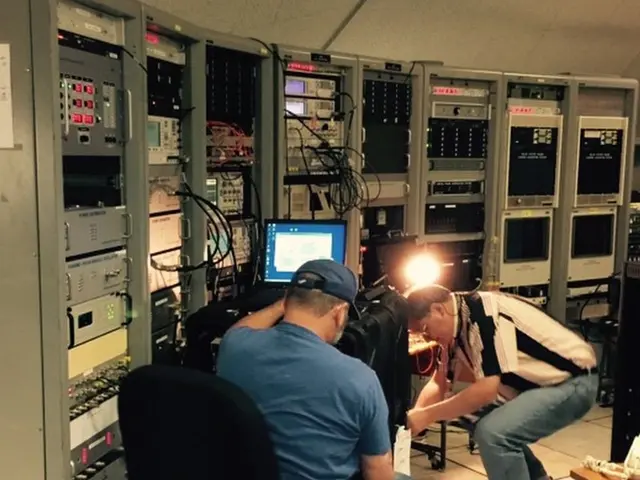 This picture shows a generator room where two people working on a laptop