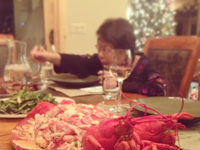 In this picture there is a woman who is sitting on the chair and she is holding the chopsticks. On...