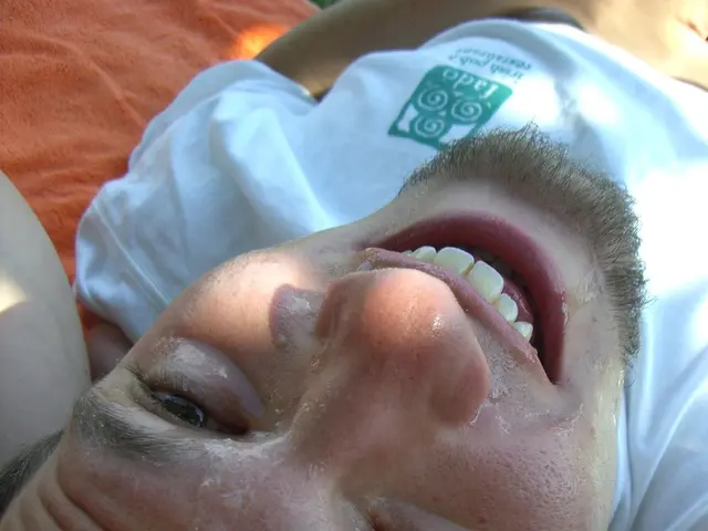 In this image we can see a person lying and smiling.