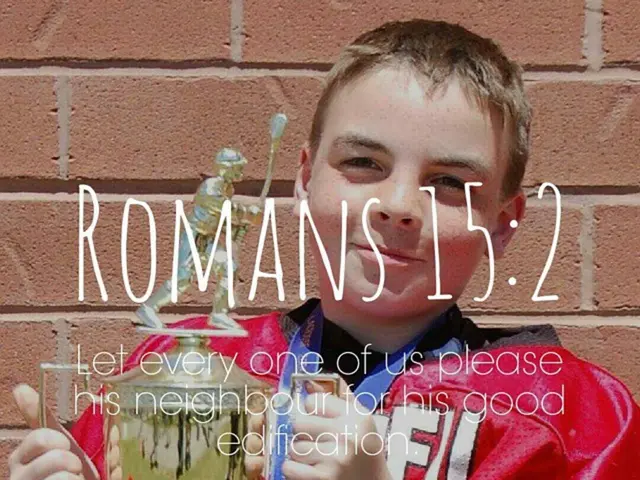 This picture shows a boy standing and holding a memento in his hand and we see a text on the...