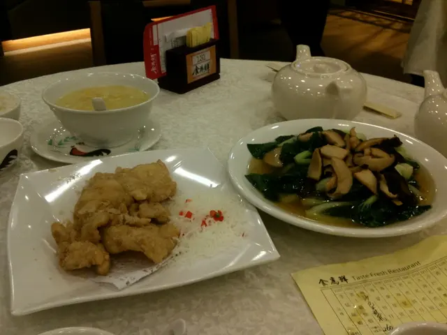 In this picture there is a table. There are few plates, papers and kettles are on the table. Two...