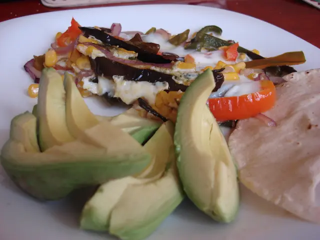 In this image I can see avocado pieces and other food items on a white plate.