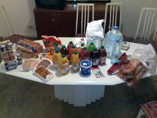 On the table bottle,food,hangers are present and near the table chairs,television is present.