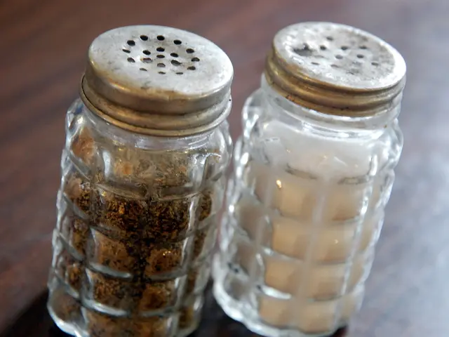 In this image we can see two glass bottles on the wooden surface and there is some food item inside...