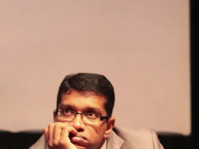 This image consists of a man who is sitting. This man is wearing blazer, tie, white color shirt ,he...