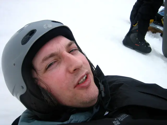 In this image there is a person wearing a helmet and black coat. At the right top of the image...