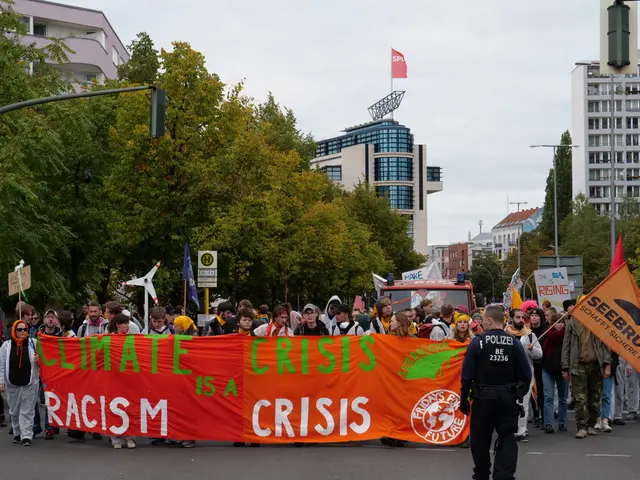 The image shows a group of people walking down a street, holding a banner that reads "Climate...