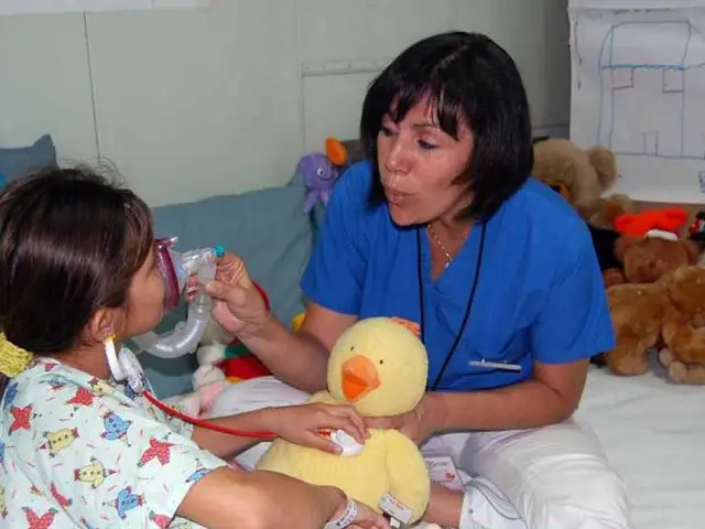 The image shows a woman in a hospital bed with a little girl sitting next to her. The woman is...
