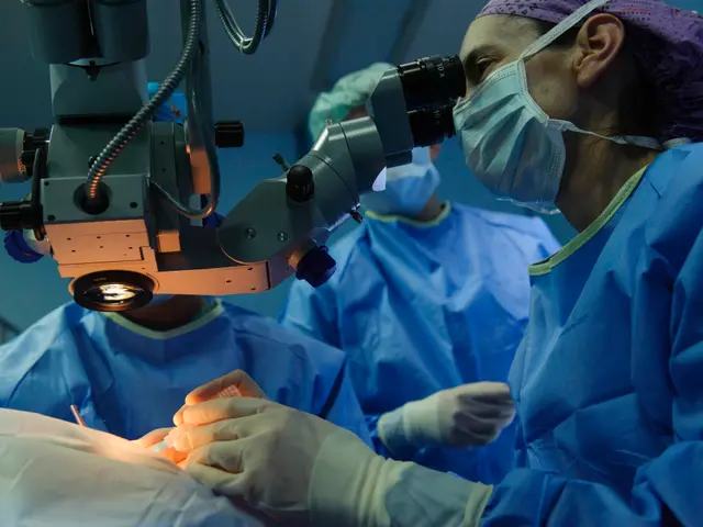 The image shows a group of surgeons wearing masks, gloves, and head caps performing surgery in an...
