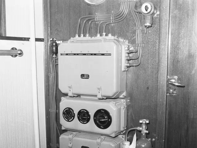 The image shows a black and white photo of a room with a door on the right side and a fire...