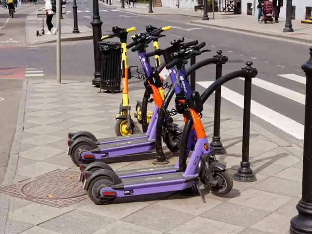 The image shows a row of electric scooters parked on the side of a street. There are people walking...