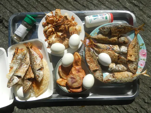 The image shows a table with a tray filled with a variety of food items, including sardines, eggs,...