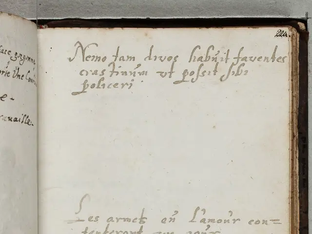 The image shows an open book with writing on it placed on a surface. The book appears to be a...