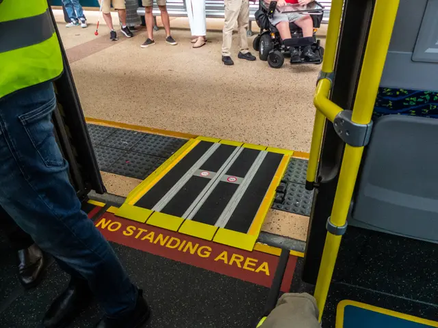 The image shows a man in a wheelchair on a bus with a no standing area, surrounded by a group of...