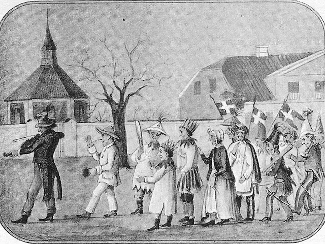 The image shows a group of people standing in front of a church, with some of them holding flags....