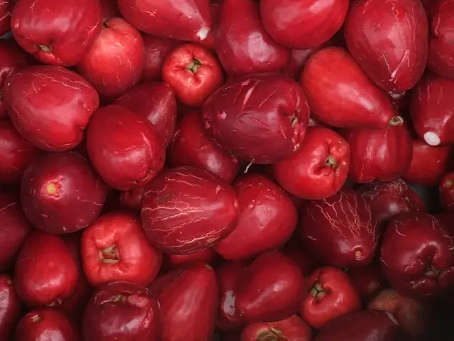 The image shows a pile of red apples sitting on top of each other, which are known for their health...